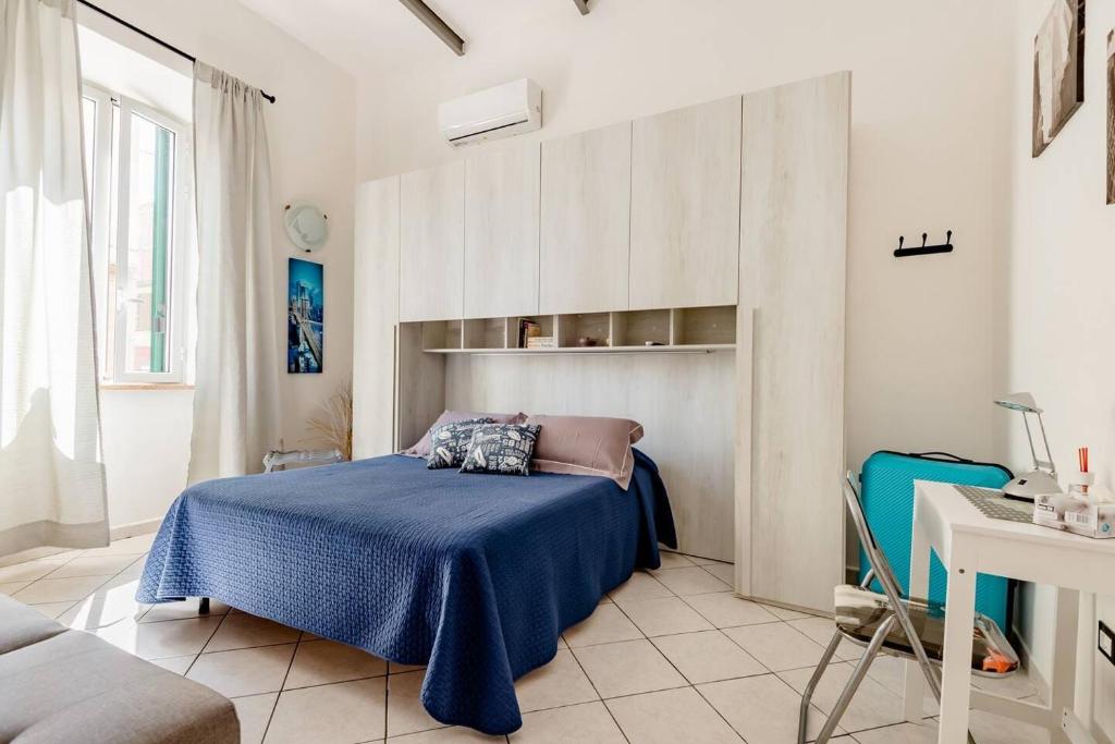 een slaapkamer met een bed met een blauwe deken bij La Casa di Beppe in Piombino