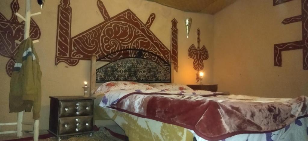 Rhessouaneにあるdoor saharaのベッドルーム1室(木製ヘッドボード付きのベッド1台付)