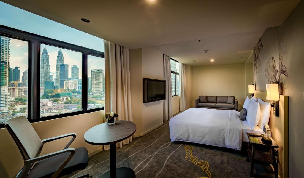 Hilton Garden Inn Kuala Lumpur - North في كوالالمبور: غرفة فندقية بسرير ونافذة كبيرة
