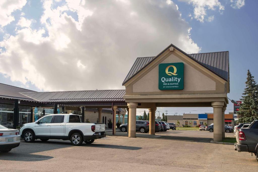 a dealership with a car parked in a parking lot at Quality Inn Winkler in Winkler