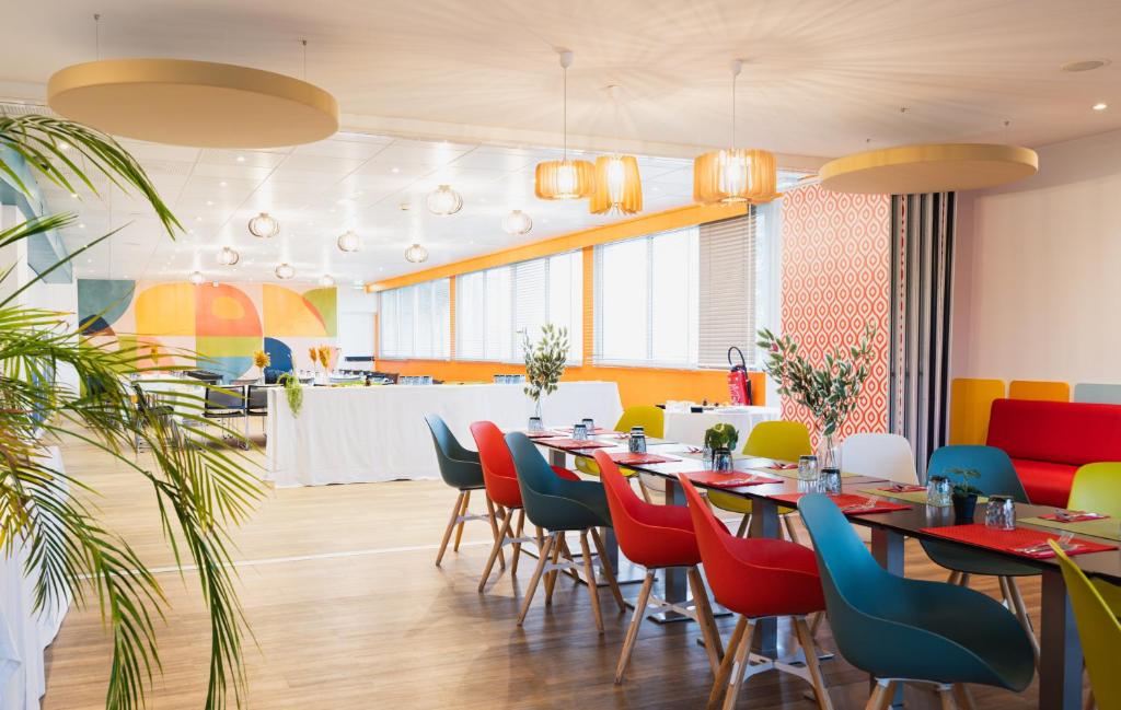 a restaurant with tables and chairs and a counter at ibis Styles Lyon Sud Vienne in Chasse-sur-Rhône