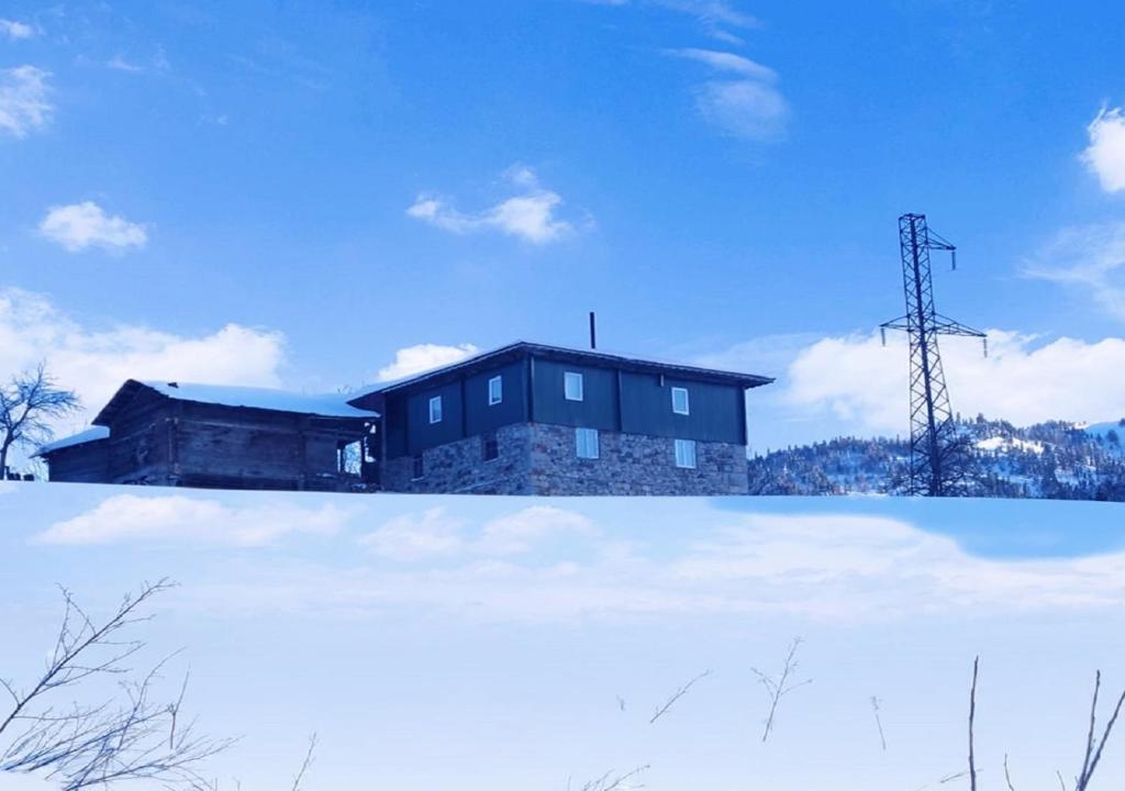 a house sitting on top of a snow covered field at Guest House Alaverdi in Khulo