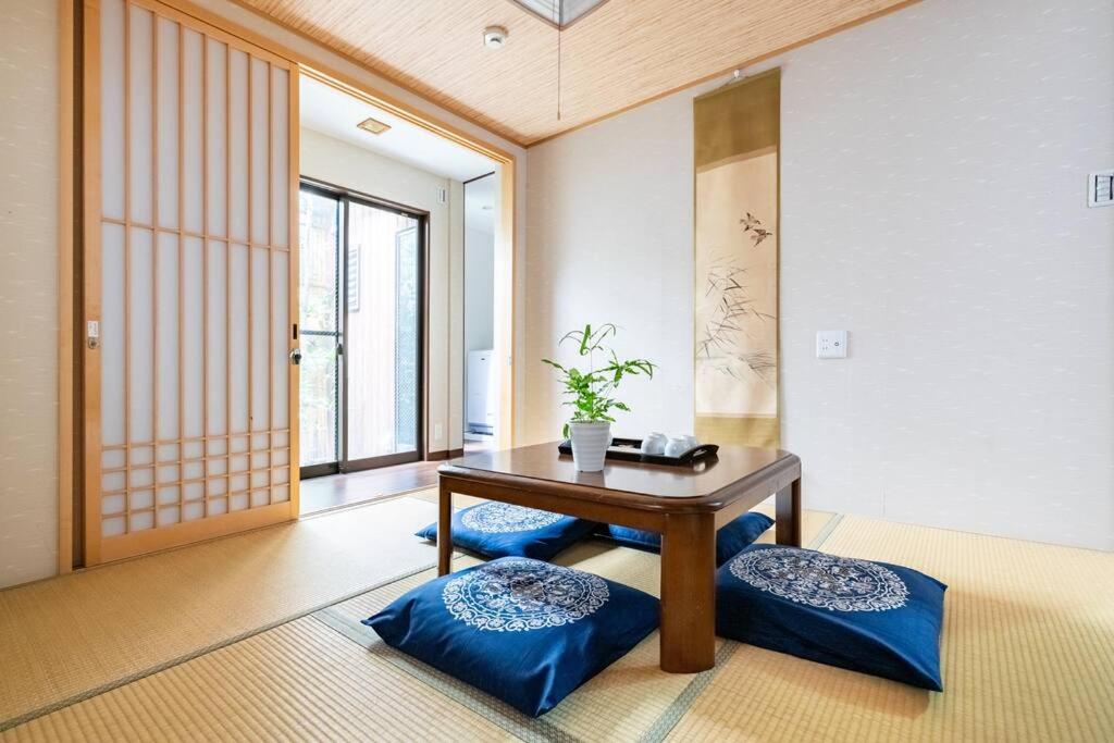 a room with a table and two blue cushioned at 平安神宮京都大学近くバス停すぐ伝統和風一棟貸し町屋浅蘇 in Kyoto