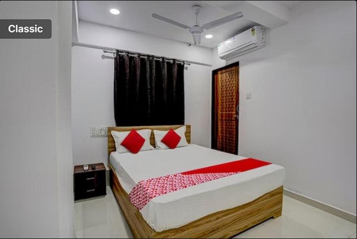 a bedroom with a bed with red pillows at Hotel Green in Surat