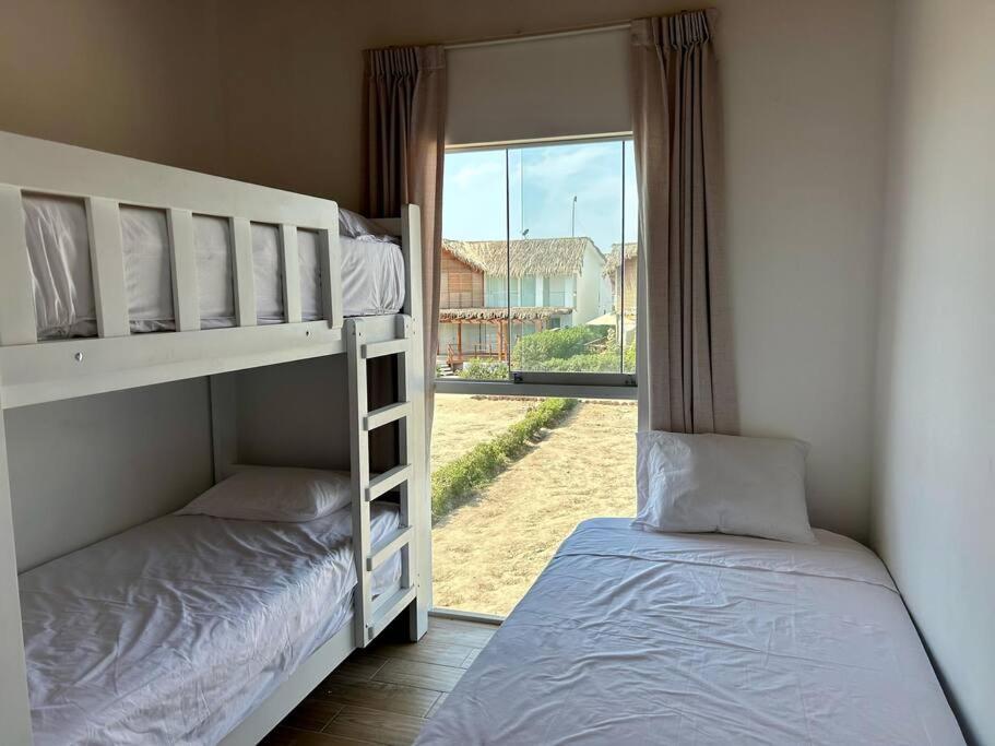 two bunk beds in a room with a window at Hermosa casa con vista al mar in Casa Blanca
