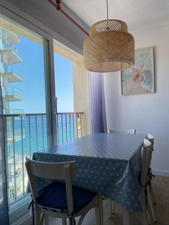 a dining room with a blue table and chairs at Apartamento Primera Línea de Mar in Platja  d'Aro