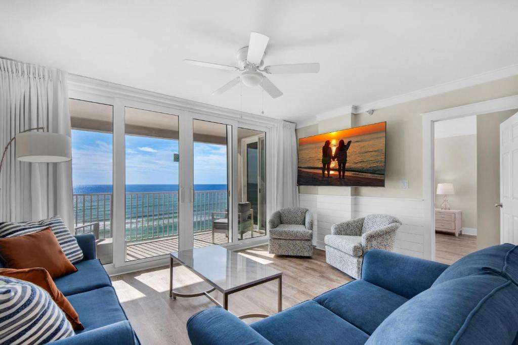 a living room with a blue couch and a view of the ocean at Island Princess 710 in Fort Walton Beach