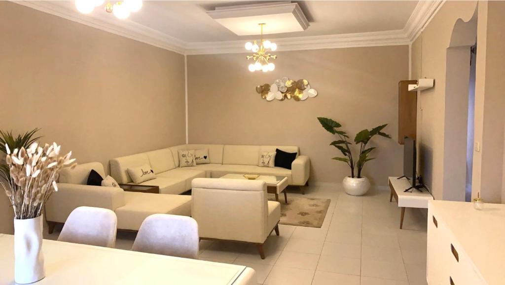 a living room with a couch and a table and chairs at Modern Apartment High Standards in Monastir