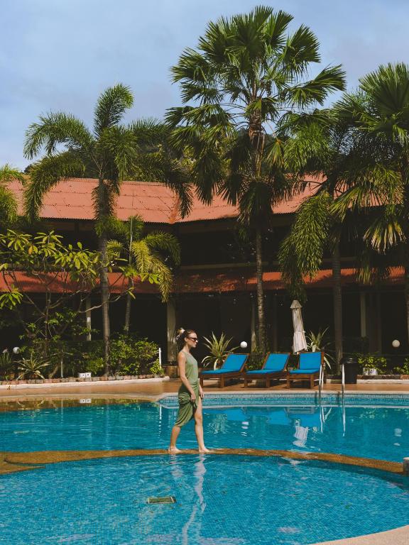 a man walking in the pool at a resort at Pangkor Sandy Beach Resort in Pangkor