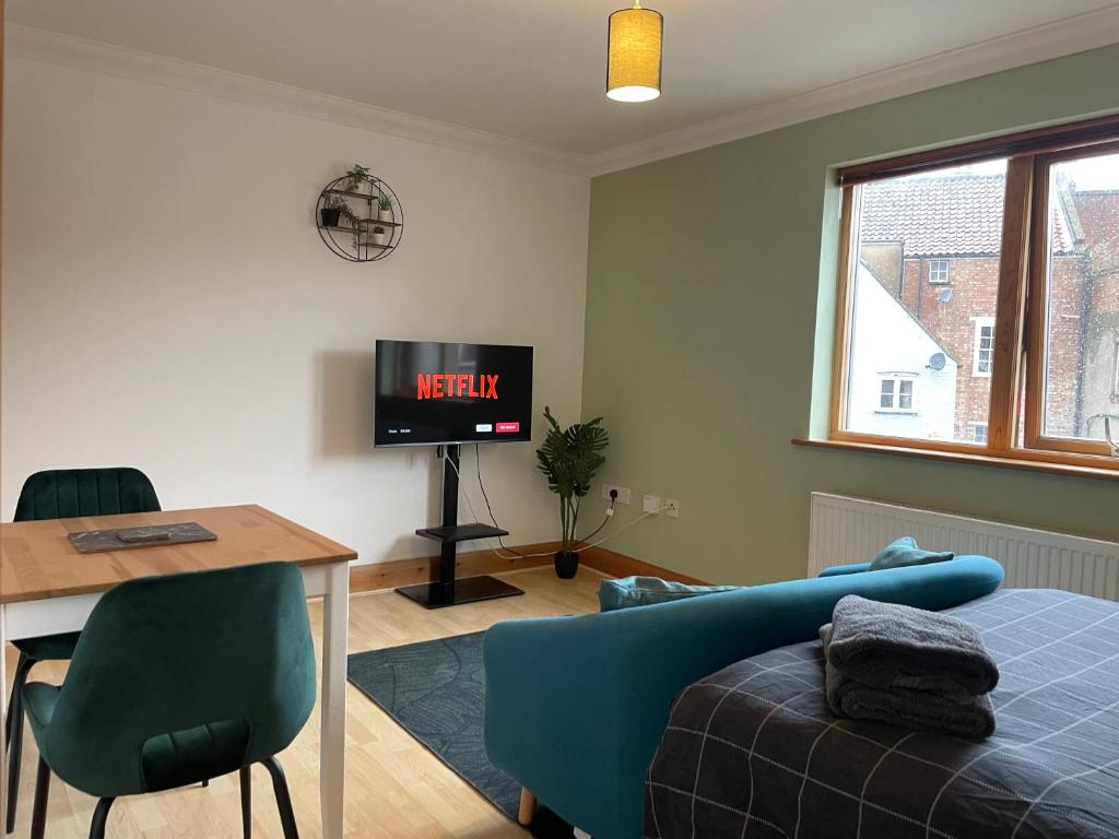 sala de estar con cama y TV en Lovely Studio Apartment in the Center of Norwich, en Norwich