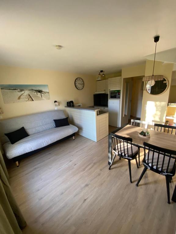 a living room with a couch and a table at l'appartement la Pommeraie in Branville