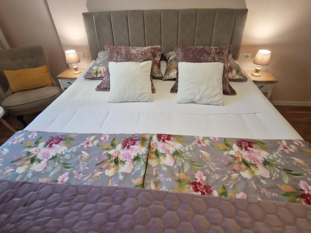 a bedroom with a large bed with a floral bedspread at La-La Rooms in Zadar