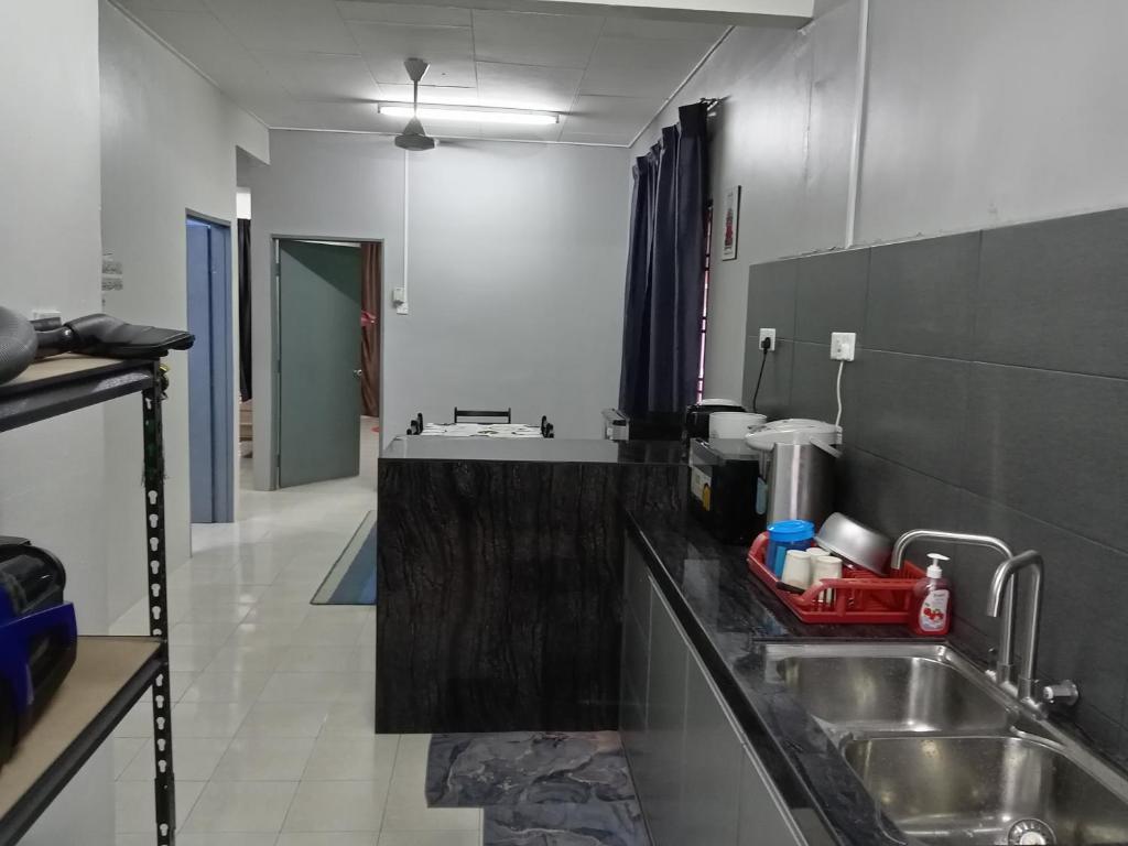 eine Küche mit einer Spüle und einer Arbeitsplatte in der Unterkunft RizqFateh Homestay in Keluang