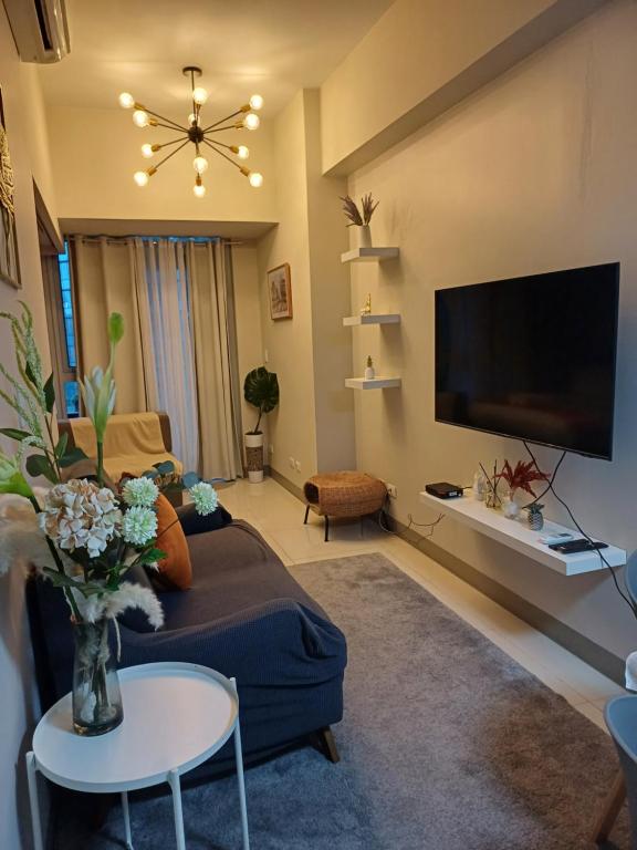 Il comprend un salon doté d'un canapé et d'une télévision à écran plat. dans l'établissement Newpointe suite, à Manille