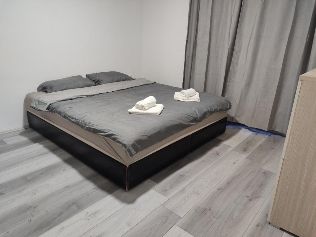 a bed with two white towels on top of it at Apartmani Hub in Niš