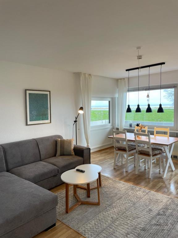 uma sala de estar com um sofá e uma mesa em MeerLeev - Panoramablick em Schillig