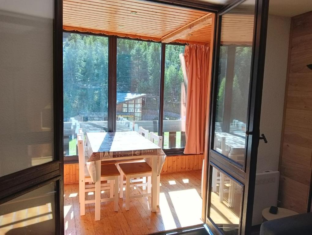 een eetkamer met een tafel en stoelen op een balkon bij Studio à la montagne in Valdeblore