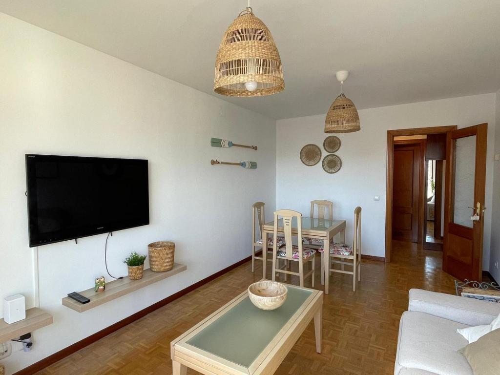uma sala de estar com uma televisão e uma mesa em La Piragua em Ribadesella