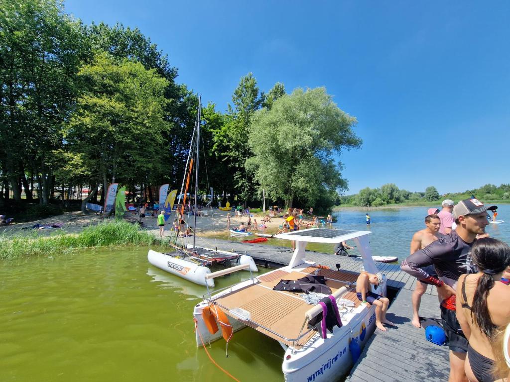a group of people on a dock with boats in the water at MARINASURF Baza Wypoczynkowa in Przeczyce
