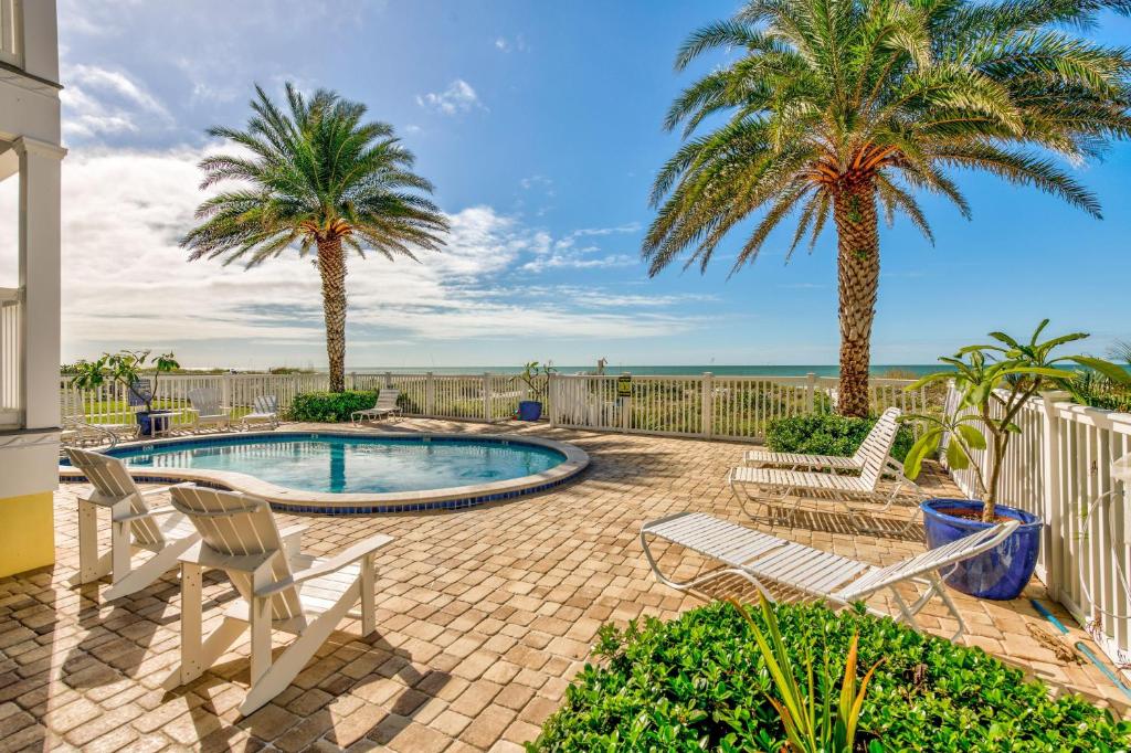 a patio with two palm trees and a swimming pool at Sunset Villas 2 in Clearwater Beach