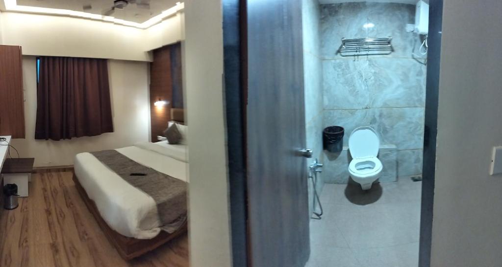 y baño con cama, ducha y aseo. en HOTEL RJ RESIDENCY, en Ahmedabad