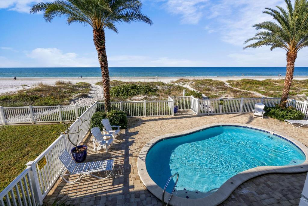 a swimming pool with the beach in the background at Sunset Villas 3 in Clearwater Beach