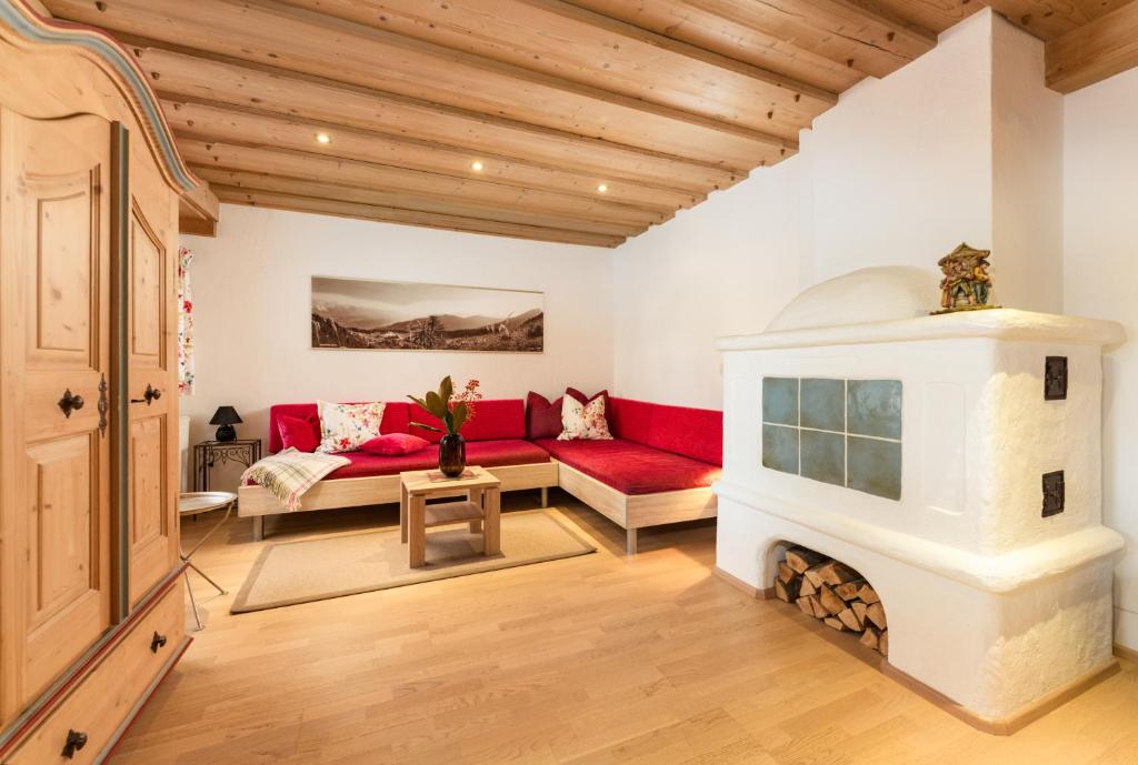ein Wohnzimmer mit einem roten Sofa und einem Kamin in der Unterkunft Appartements Knappenhaus by Schladming-Appartements in Schladming