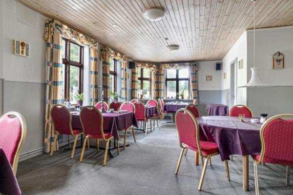 un comedor con mesas púrpuras y sillas rojas en Lynge kro & Hotel 