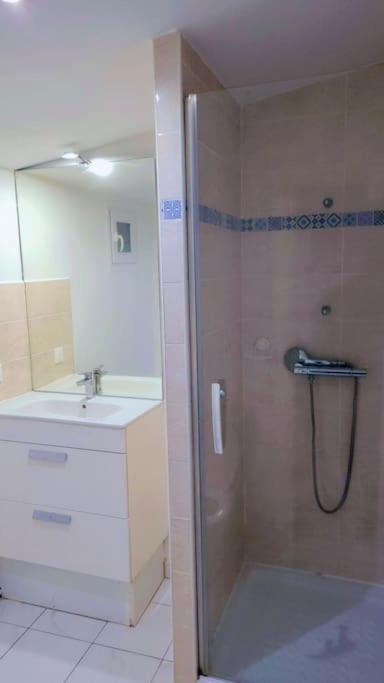 een badkamer met een douche en een wastafel bij beau studio in Stains