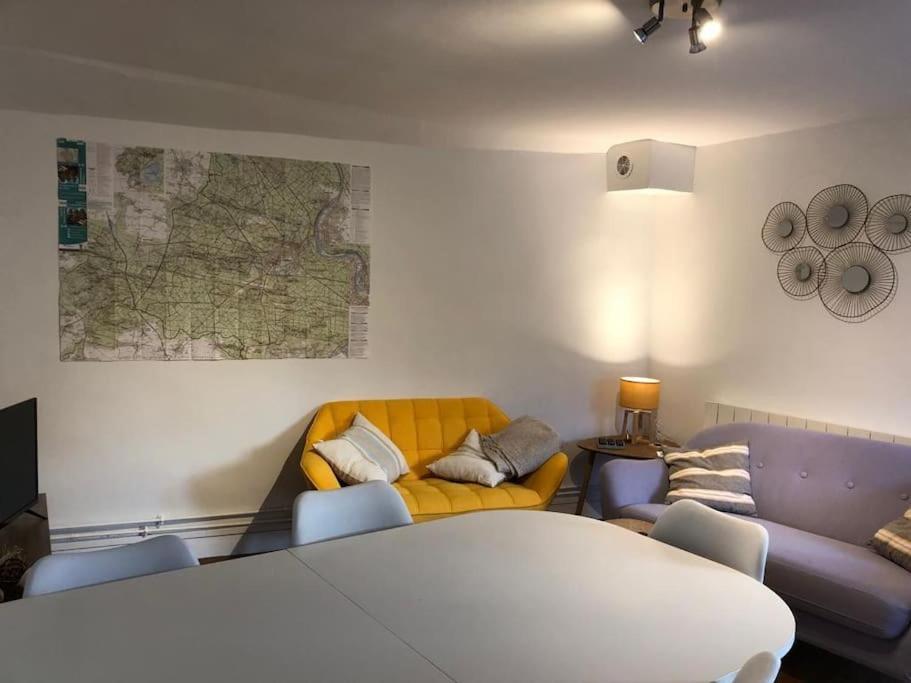 a living room with a couch and a table at Gîte le long rocher in Veneux-les-Sablons