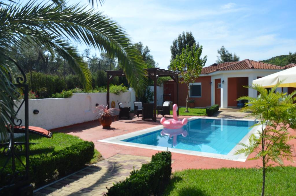 un cortile con piscina e una casa di Villa Platanias ad Agia Paraskevi