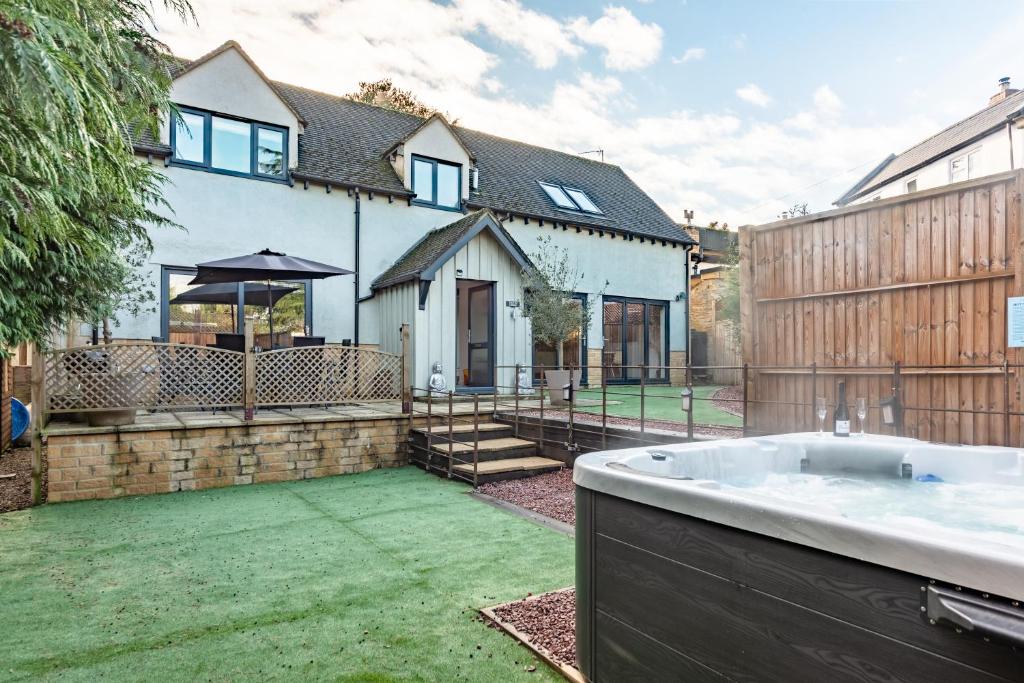 a bath tub in the yard of a house at Cotswold holiday let with hot tub - The Old Garage in Chipping Norton