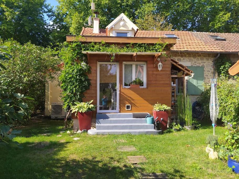 une petite maison avec des escaliers menant à la porte d'entrée. dans l'établissement Gîte Les Lilas, à La Genevraye