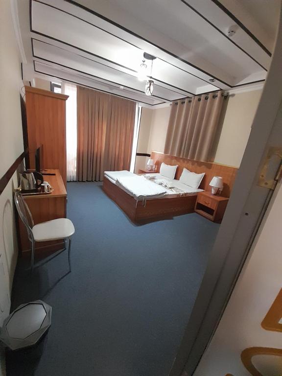 um quarto com uma cama, uma secretária e uma cadeira em Hotel Boutique Al Hayit em Bukhara