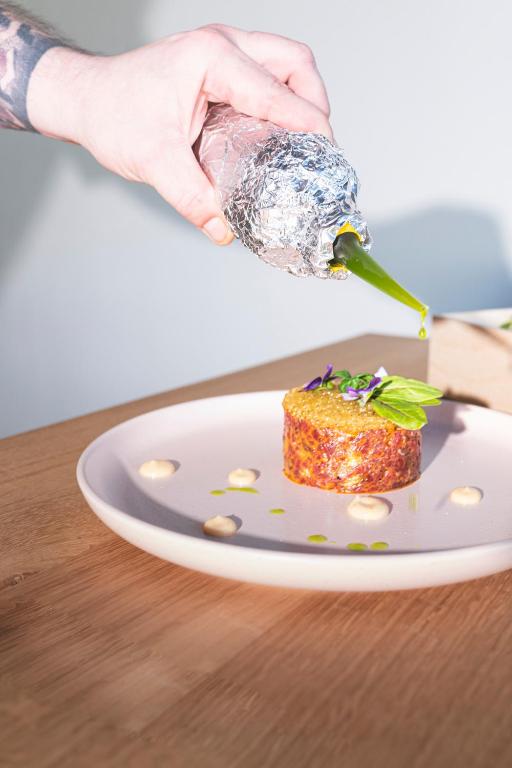 a person holding a piece of food on a plate at Hotel Gamshag in Saalbach-Hinterglemm