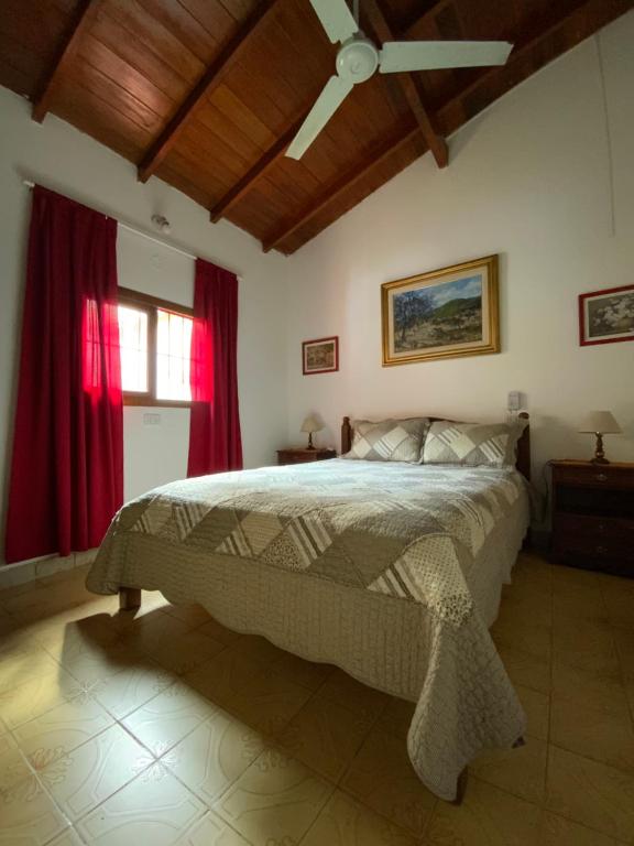 Un dormitorio con una cama grande con cortinas rojas. en Complejo Quimey No se alquila a jóvenes y se reserva con el 30 porciento del total mediante depósito bancario, en Villa Gesell