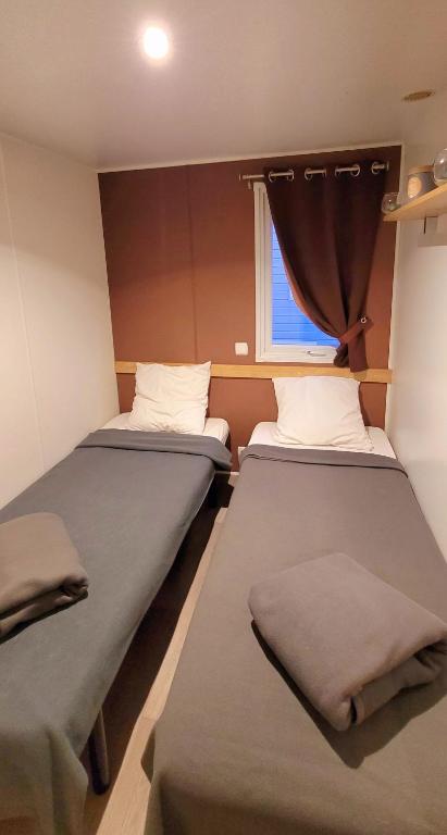 two beds in a small room with a window at Camping Aux Portes De Cassis in La Bédoule