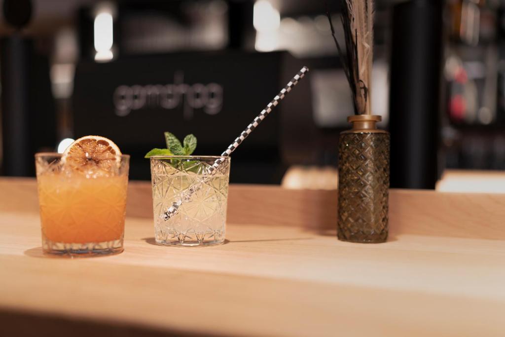 two cocktails sitting on a table with a vase at Hotel Gamshag in Saalbach-Hinterglemm