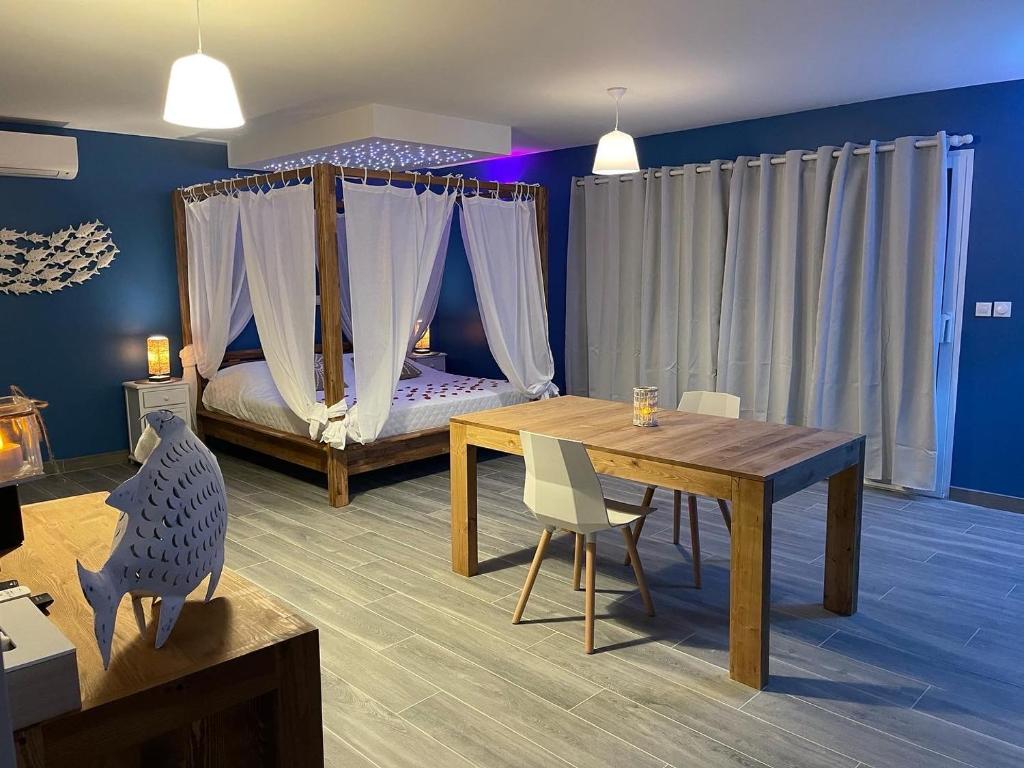 uma sala com um quarto com uma mesa e uma cama em La Paillote Exotique Spa em Beaucaire