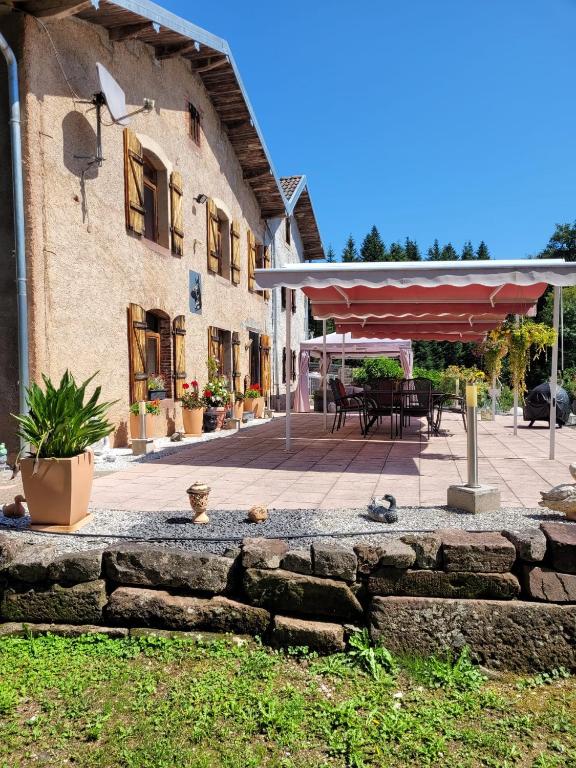 une terrasse avec une table et un parasol dans l'établissement Relais nature et randonnées, à Écromagny