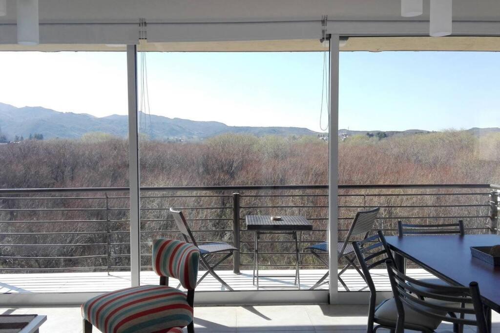 una veranda protetta con sedie e un tavolo di Departamento con vista al lago a Potrero de los Funes