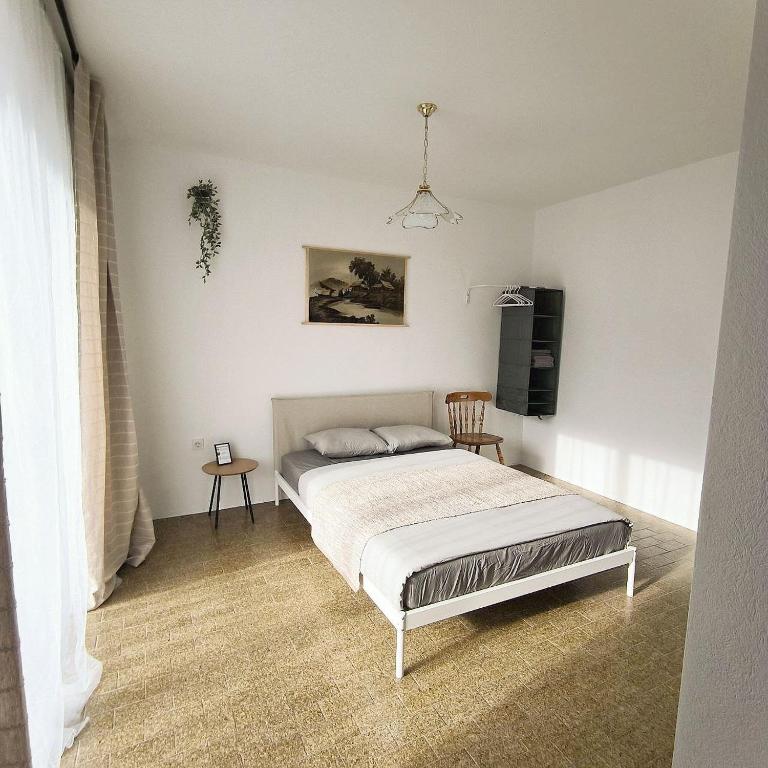 een slaapkamer met een bed in een witte kamer bij GuestHouse Maison Standard in Kula