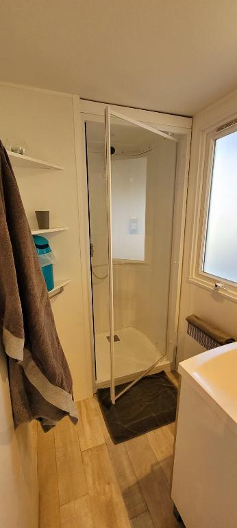 a bathroom with a glass shower door with a window at Camping Aux Portes De Cassis in La Bédoule