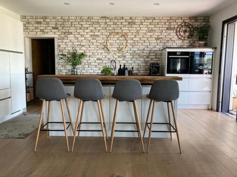 a kitchen with a counter with four chairs around it at Haus mit viel Platz, Terrasse und Garten in Alfter