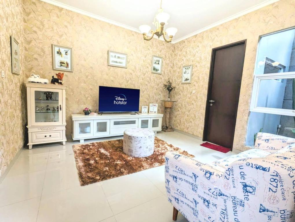 een woonkamer met een bank en een tv bij Cottonwood Villa @Setra Murni in Bandung