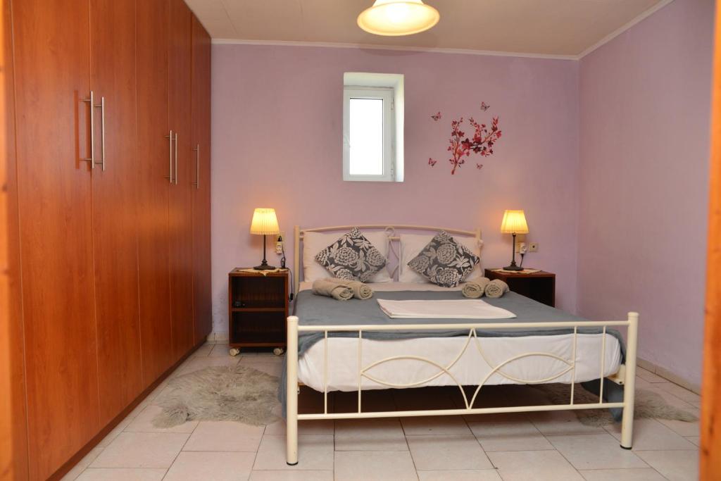 a bedroom with a bed with two night stands and two lamps at Xenios Dias in Megáli Vrísi