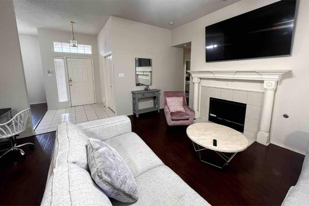 a living room with a white couch and a fireplace at Amazing Location Home w/ Bathtub in Frisco