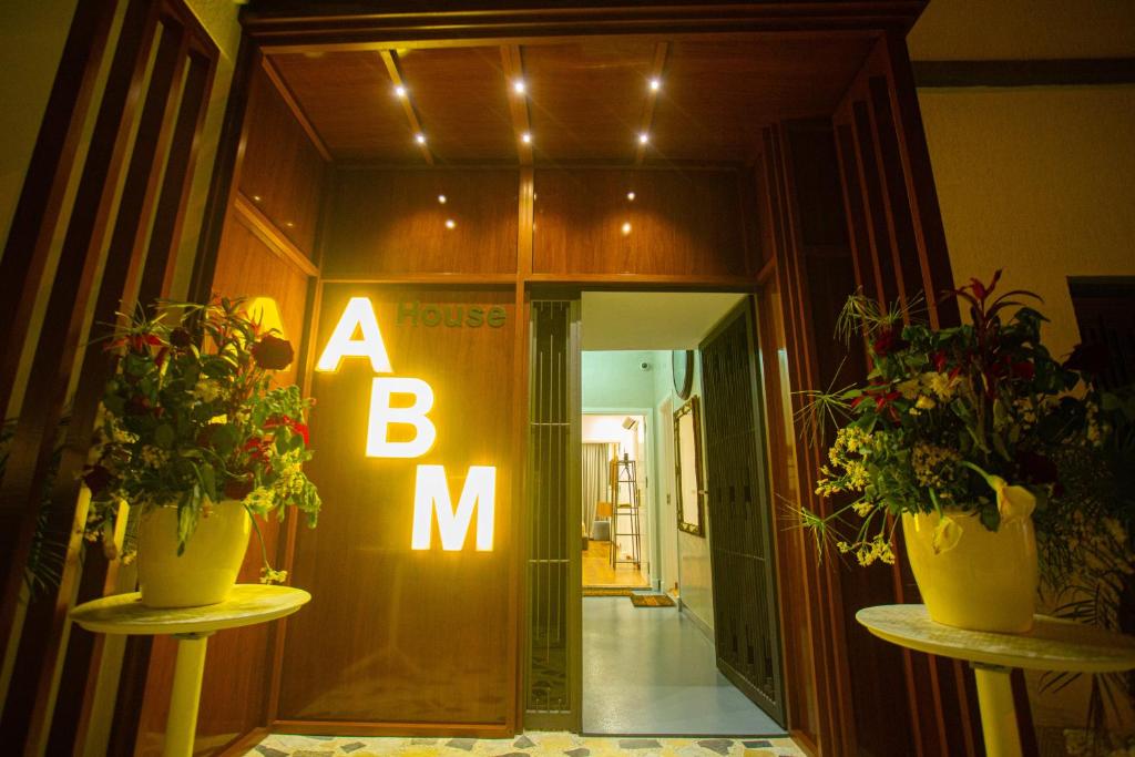 un panneau bm dans un couloir avec deux plantes en pot dans l'établissement ABM house, à Tanger