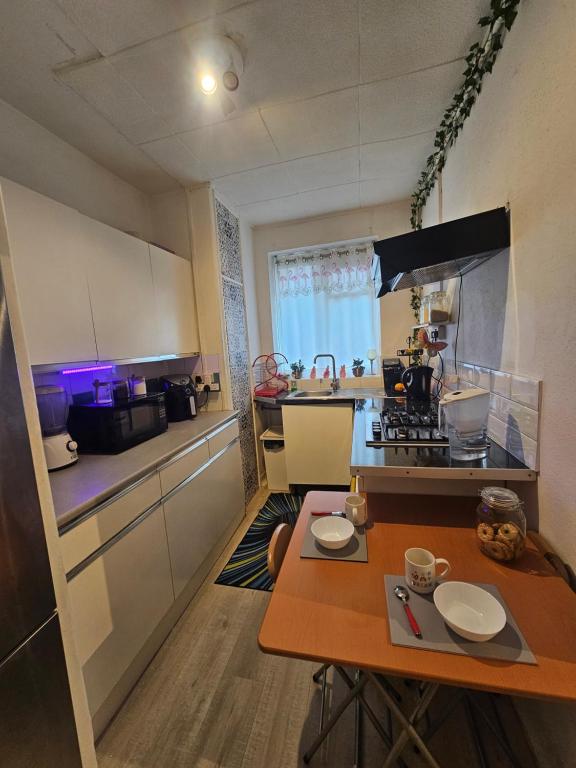 a small kitchen with a wooden table in a room at Cheshunt House in London