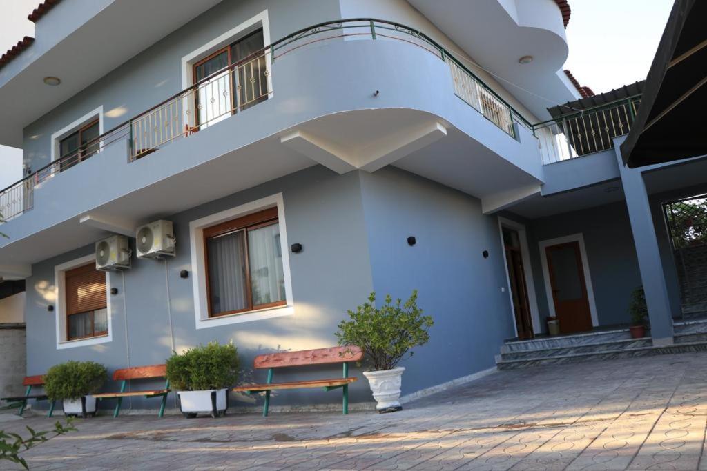 a building with two benches in front of it at Albora Guest House in Fier